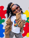 Girl in sunglasses and a tan jacket wearing the white Every Step Matters tee by 4C Sensory Center